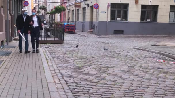 Mann mit Kamera und älterer Vater in Masken spazieren durch die Stadt — Stockvideo