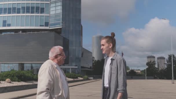 Senior far pratar med ung son stående på stadens gata — Stockvideo