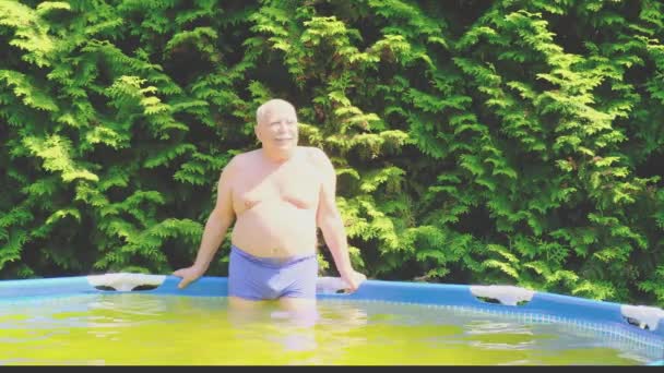 Muž stojí v nafukovací bazén s teplou vodou a vlny rukou — Stock video