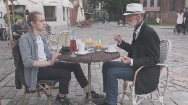Olumlu baba ve oğul sokak kafesinde vakit geçirir.