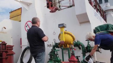 Birinci subay ve eşek kontrol yakıtı tankerde pompalanıyor.