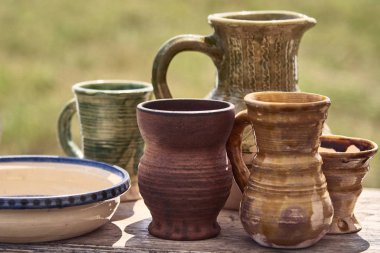 Sofra seramik kil kupa, kahverengi renk bir sürahi masada vardır