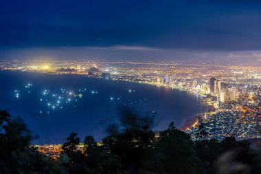Ban Co Zirvesi 'nden Da Nang' ın panoramik görüntüsü. Parlak şehir ışıkları, yüksek binalar, Han Nehri üzerindeki aydınlık köprüler ve hareketli caddeler..