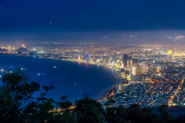 Ban Co Zirvesi 'nden Da Nang' ın panoramik görüntüsü. Parlak şehir ışıkları, yüksek binalar, Han Nehri üzerindeki aydınlık köprüler ve hareketli caddeler..