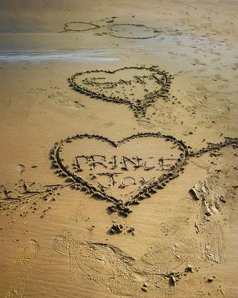 연인들은 해변의 모래에 시간으로 사랑의 표시를 그린다 2018 — 스톡 사진