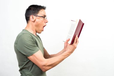 Bir kitapta onu çok şaşırtan bir şey okuyan bir adam. Orta atış. Beyaz arkaplan.