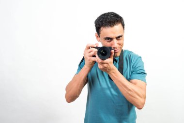 Elinde fotoğraf makinesi olan gülümseyen bir adam kameraya bakıyor. Orta atış. Beyaz arkaplan.