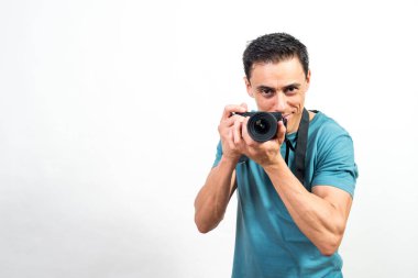 Elinde fotoğraf makinesi olan gülümseyen bir adam kameraya bakıyor. Orta atış. Beyaz arkaplan.