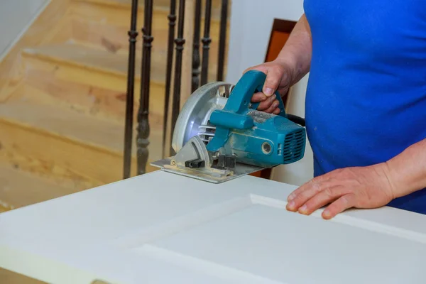 using circular saw for cutting wood door hands of the builder, man construction and home renovation, repair tools