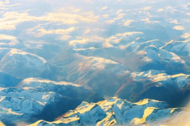 Kabarık beyaz bulutlar ve mavi gökyüzü uçaktan görünüyor..