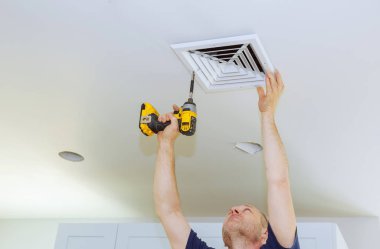 HVAC yükleme, Isıtma Havalandırma ve soğutma hava filtresi değiştirdikten sonra adam. Duvardaki delik