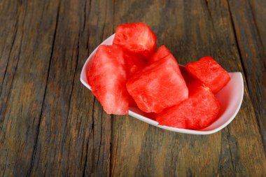 Adet ahşap arka plan taze çiğ karpuz kesmek