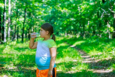 Bir plastik içme çocuk yaz Park doğada saf su şişe