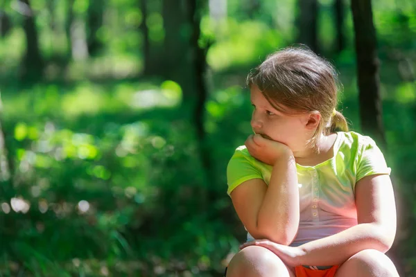 Açık portre sarışın saç sonbahar parkta oturan ile küçük kız gülümsüyor ve sol tarafında görünüyor.