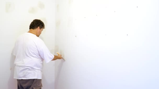 Hombre alineando una pared con espátula trabajando con masilla y espátula pared — Vídeos de Stock