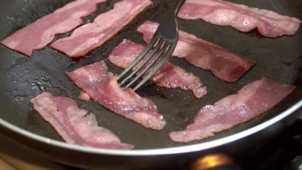 Controle deslizante macro tiro de três fatias de fritar bacon cozido da frigideira . — Vídeo de Stock