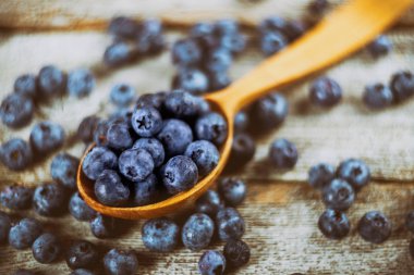 Yaban mersini ile tahta kaşıkla üstten görünüm ahşap tablo