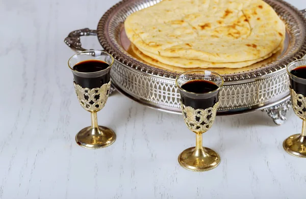 Holy communion in church, cup of glass with red wine, bread on wooden table. Christians symbols concept.