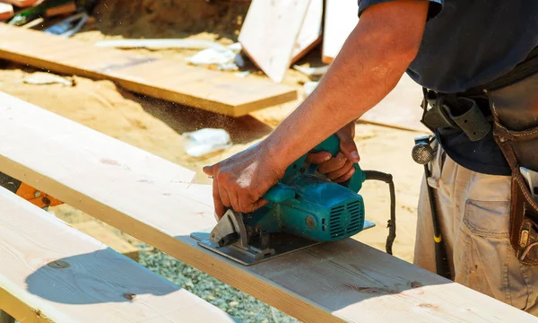 Yakın çekim bir marangoz ahşap büyük bir tahta yeni bir ev constructiion proje kesmek için bir daire testere kullanarak