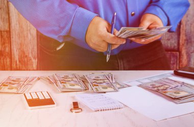 Adam el anlattıklarında dolar. para sayar. yeni yüz dolar faturaları