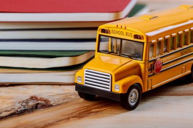 İçin renkli kalem ve defterini, oyuncak sarı okul otobüsü ahşap arka plan geri okul kavramı