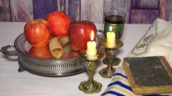 Jewish holiday shofar, torah book, honey, apple and pomegranate rosh hashanah traditional holiday symbols.