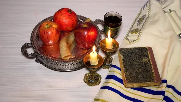 Jewish holiday shofar, torah book, honey, apple and pomegranate rosh hashanah traditional holiday symbols.