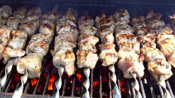 Grilled Gourmand Chicken Skewers. Juicy roasted chicken skewers,made of white meat and bacon, being turned on the bbq.