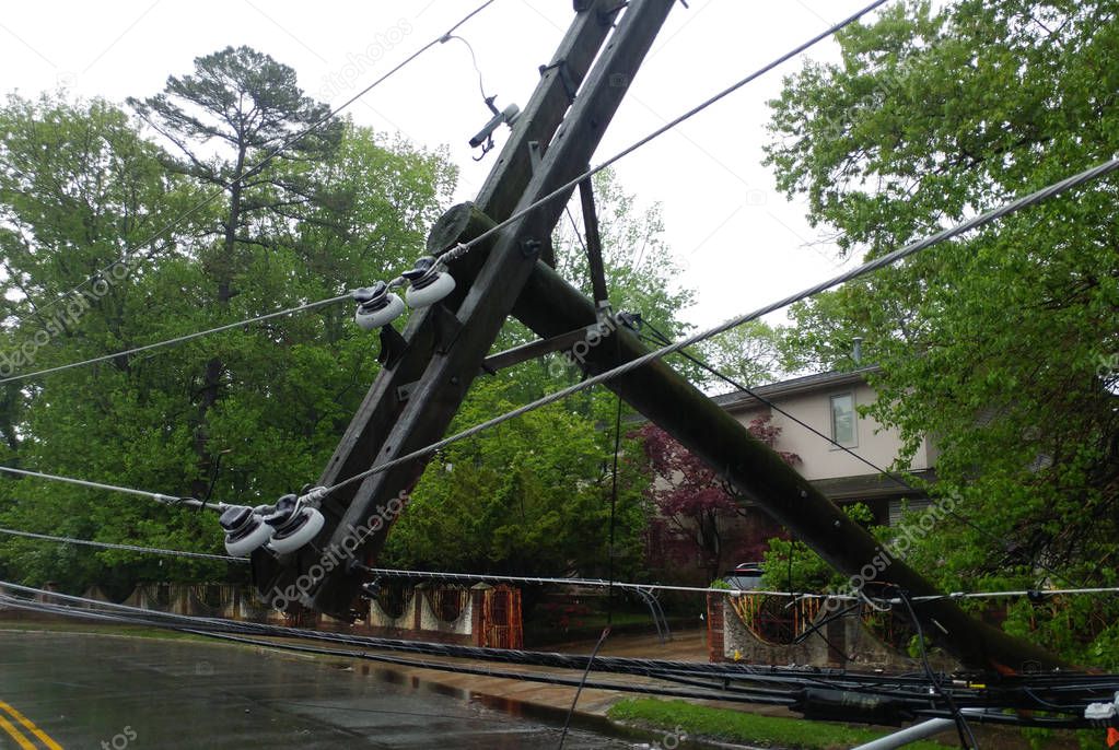 The storm caused severe damage to electric poles power lines over a road after Hurricanepoles falling tilt.
