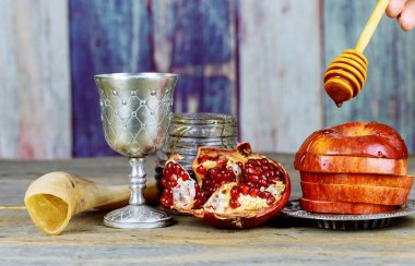 Rosh hashanah jewesh tatil kavramı - shofar, Tevrat kitap, bal, elma ve nar ahşap masa üzerinde. Geleneksel tatil sembolleri. Kipa bir yamolka