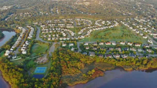 Panorama över tidig morgon i Usa nära floden. nya bostäder nära vattnet i sovande området bostadssektorn Sunlights över byggnader — Stockvideo