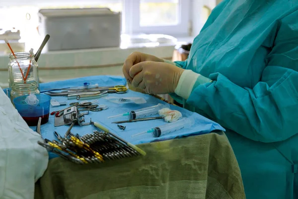 Detail shot of steralized surgery instruments with surgery tools on table with doctor on background