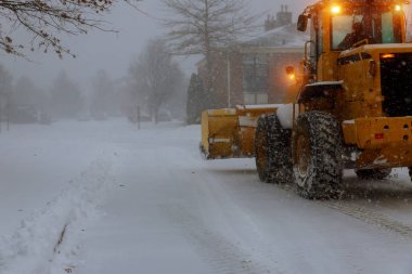 Kar makinesi kaldırarak temizler karda sokaktan kar yağışı sırasında