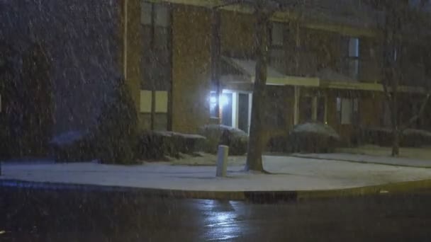 Många små snöflingor faller på mot bakgrund av en gatlykta, Utomhus belysning på natten — Stockvideo