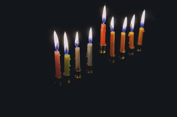 Colorful candles lite on the traditional Silver Hanukkah menorah