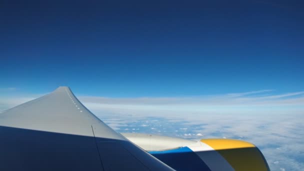 Concepto de ventana de vista de avión. Ver en la ventana del avión ver motor y ala en la nube y el cielo azul o azul cielo en la tierra hermosa . — Vídeo de stock