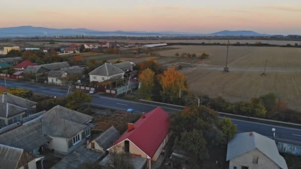 A profile moving aerial establishing shot of a typical small town at sunset. — Stock Video