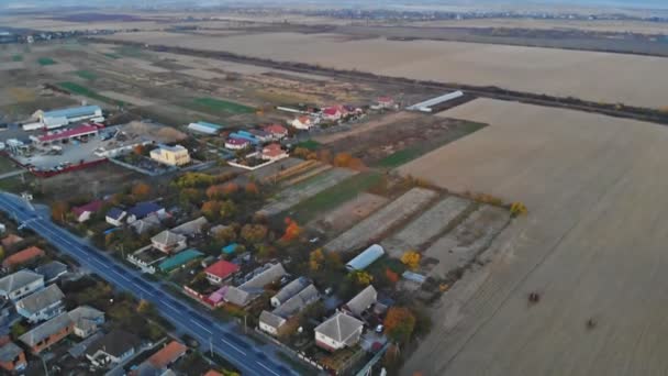 Tiro aéreo bela pequena aldeia perto do campo verde no outono — Vídeo de Stock