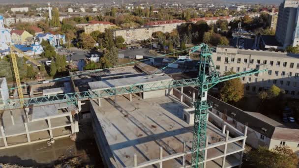 Hoog stijgingsgebouw in aanbouw. De site met kranen tegen blauwe hemel. — Stockvideo