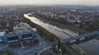 Uzhhorod Ukrayna 'nın sonbaharda Uzh Nehri üzerinde günbatımında yukarıdan küçük bir kasabanın panoramik görüntüsü