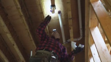 Tesisatçı yakın plan çekimde plastik tuvalet beyaz borusunu yapıştırdı.