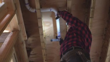 Tesisatçı plastik tuvalet beyaz borusunu yakın çekim için yapıştırıyor.