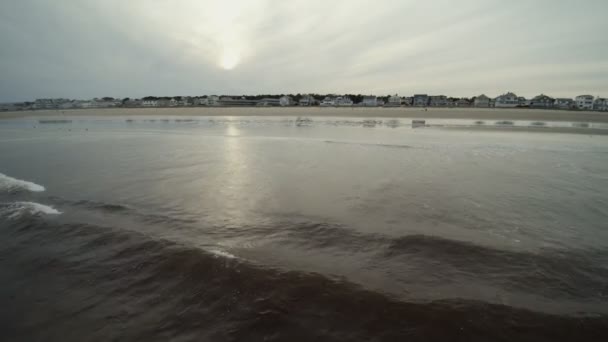 Miękkie fala ocean na piaszczystej plaży w ciepłe złoto światło zachód słońca. Tło. — Wideo stockowe