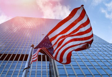 Amerikan bayrağı mavi gökyüzü gökdelenler karşı sallayarak.
