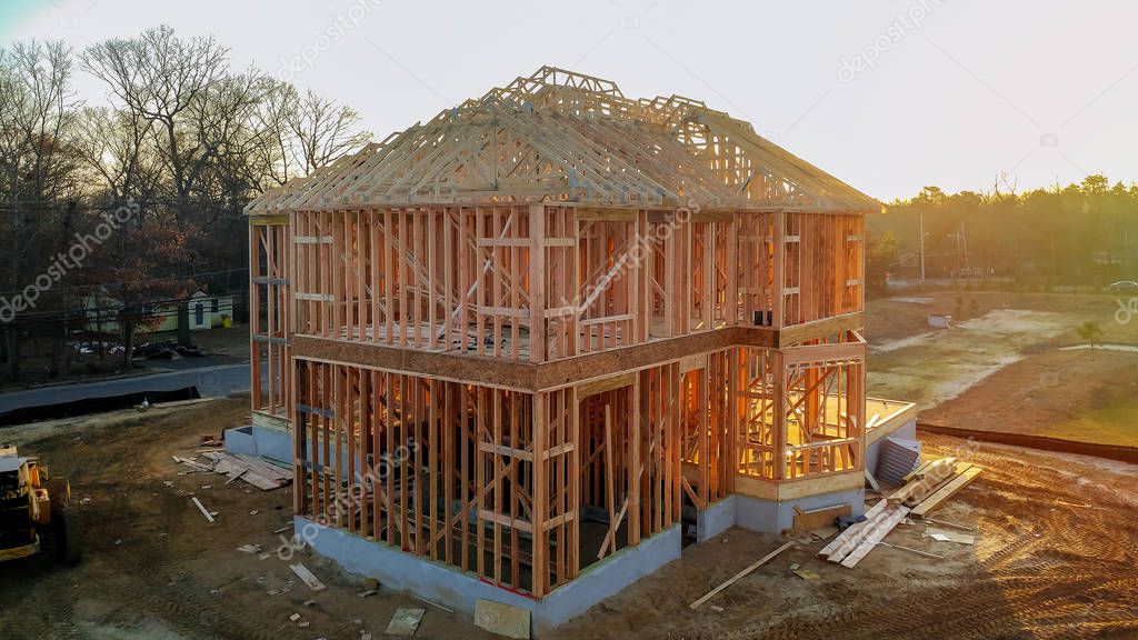A stick built house under construction New build with wooden truss, post and beam framework.