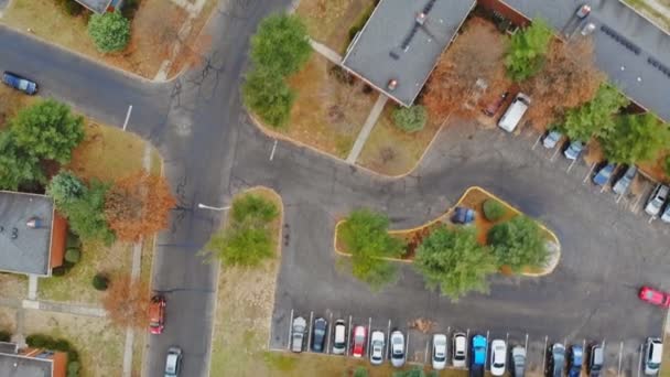 Colpo aereo guardando dall'alto verso il basso sullo sviluppo abitativo urbano - quartiere residenziale di alberi gialli e tetti — Video Stock