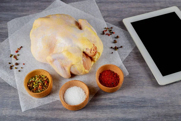 organic raw whole chicken on wooden rustic background and a prescription tablet