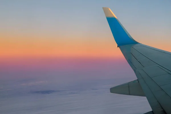 日の出の空に飛行機空を飛んでいると — ストック写真