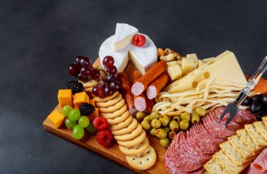 Aperatif set çeşitli et çeşitli, peynir, kraker, yeşil zeytin, fındık ve ahşap masa arka plan üzerinde çilek ile