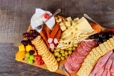 Kesme tahtası ile set dekor yeşil zeytin, incir, fındık ve taze çeşitli peynir kompozisyon üzerinde meyveleri closeup